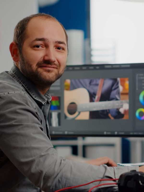 videographer-smiling-at-camera-working-on-computer.jpg
